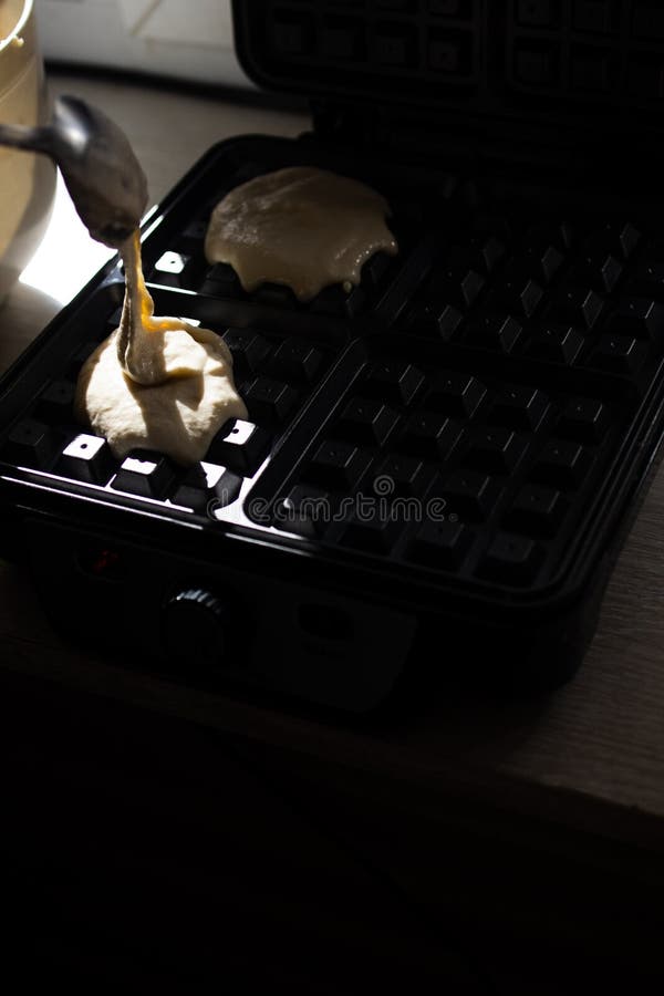 Cooking Belgian Waffles in a Waffle Iron. Pour in the Dough Stock Image