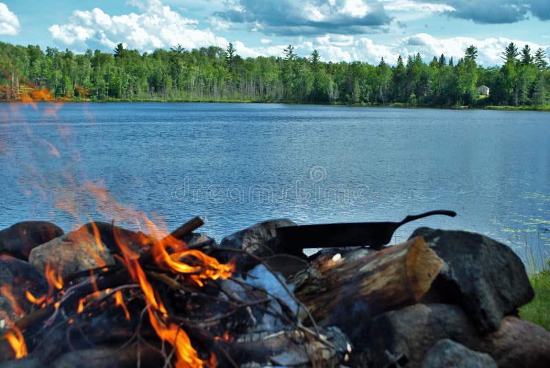Cooking on a Castiron Skillet Over a Camp Fire Next To the Lake Stock