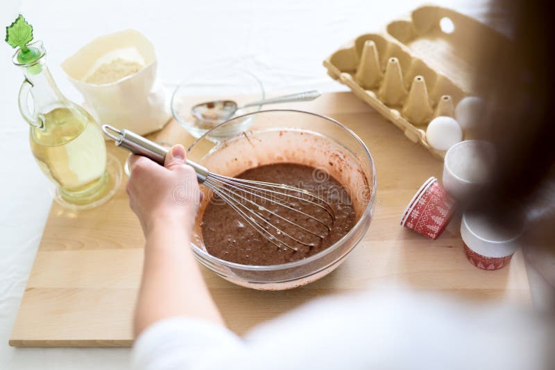 Cooking Christmas chocolate muffins. Mixing ingredients for brownies, cupcakes, pancakes. Woman hands preparing royalty free stock photography Cooking Christmas chocolate muffins. Mixing ingredients for brownies, cupcakes, pancakes. Woman hands preparing royalty free stock photography