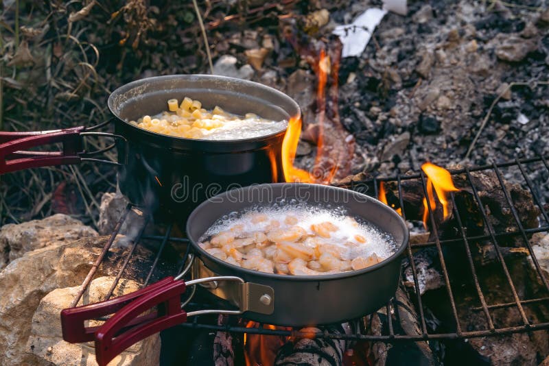 Cooking Dinner in Metal Utensils for Camping. Campfire at the Campsite