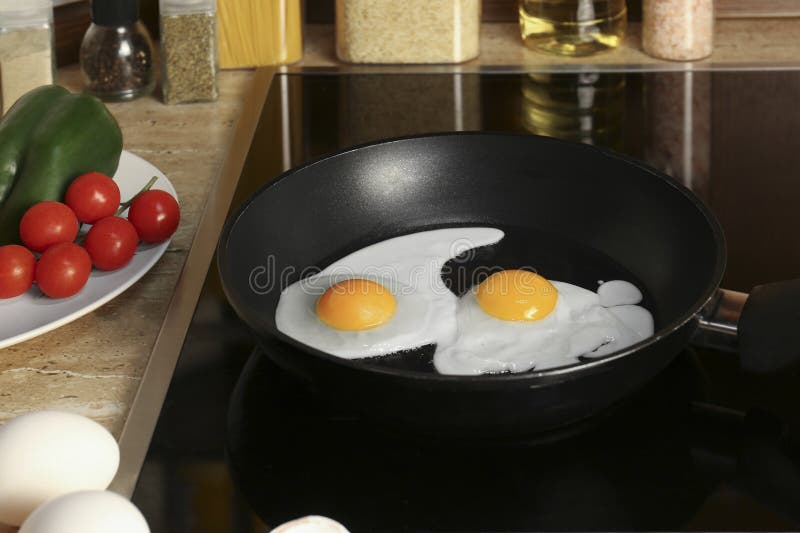 Cooking Eggs for Breakfast in Frying Pan on Cooktop Stock Photo Image