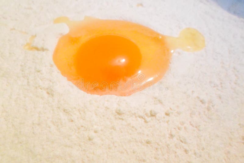 Broken Egg in White Flour. Egg Yolk and Egg White in Flour Cooking