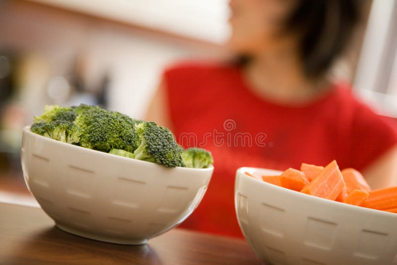 Giovane donna cucinare cibo sano con un sacco di verdure.