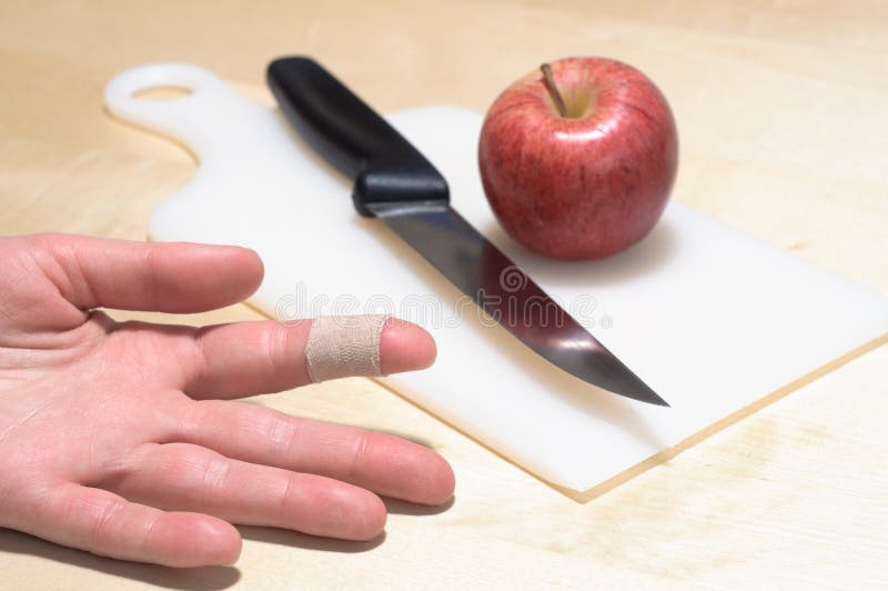 Un cuchillo, manzana lastimar dedo banda apoyo yeso sobre el.