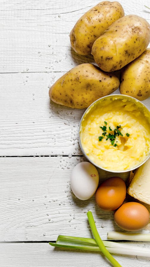 Cooking mashed potatoes ingredients: potatoes, milk, eggs, butter and other on a white wooden table. royalty free stock photos Cooking mashed potatoes ingredients: potatoes, milk, eggs, butter and other on a white wooden table. royalty free stock photos