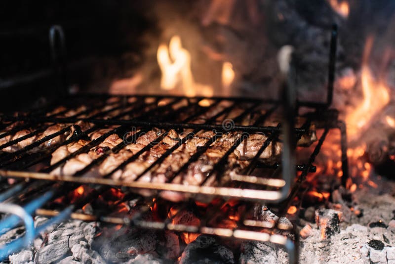 Cooking Meat on the Grill in a Fireplace with Embers Stock Image