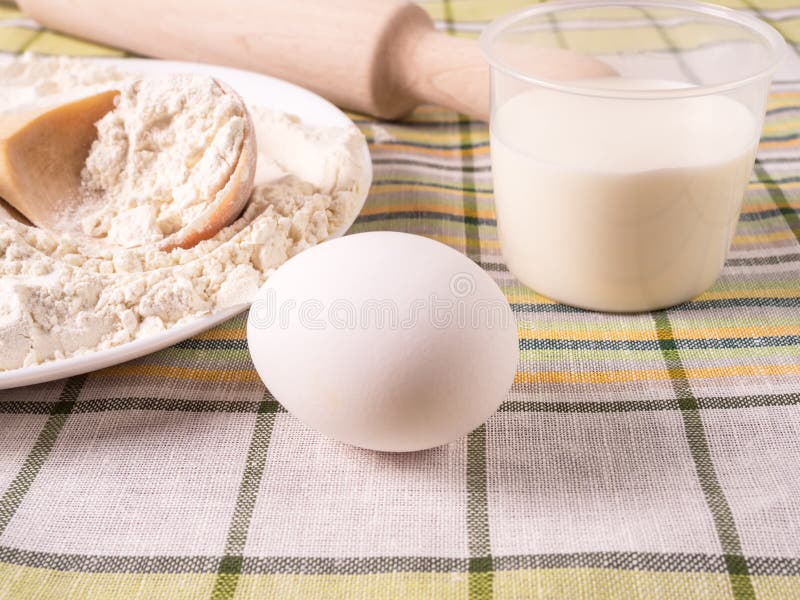 Cooking Milk, Eggs and a Plate of Flour Standing on a Table Stock