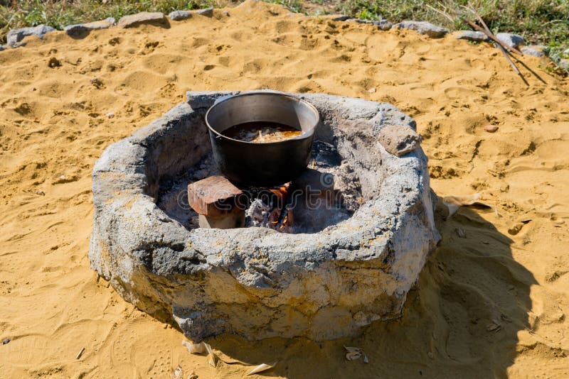 Cooking pilaf in a large cauldron over an open fire. Traditional big metal pot stock images, royalty-free photos and pictures