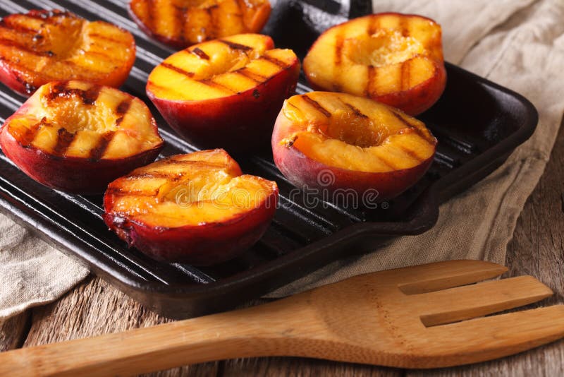 Cooking Ripe peaches on a grill pan close-up. horizontal