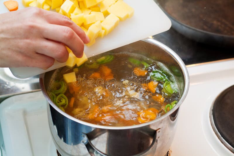 Chef aggiungendo le verdure in acqua bollente per la cottura.