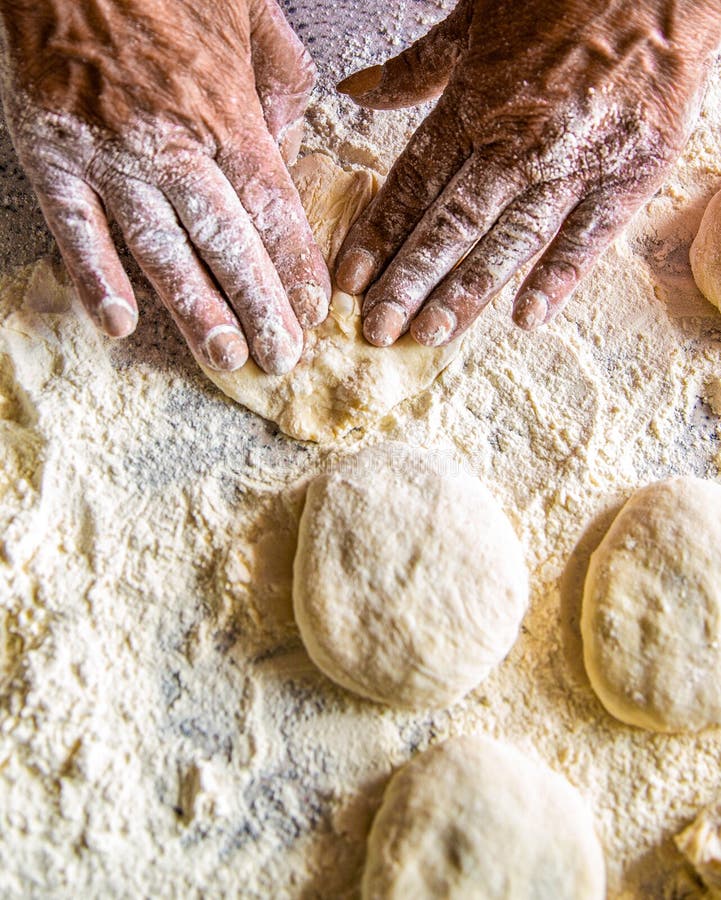 Cooks dough for baking, pieces of raw dough. Dough in the women's hands. Process of making pies, hand. Hands pie dough stock images