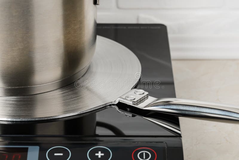 Cookware on a Stainless Steel Heat Diffuser Plate Over a Cooktop. Kitchen  Appliance for Induction Hob Allows To Use Small Diameter Stock Image -  Image of kitchenware, conductivity: 194094277