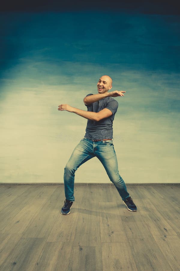 Cool Bald Man in a Gray T-shirt and Jeans Jumping and Fooling Around ...