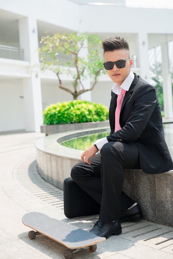 Portrait Of A Stylish Male In A Black Suit And Red Tie Isolated On