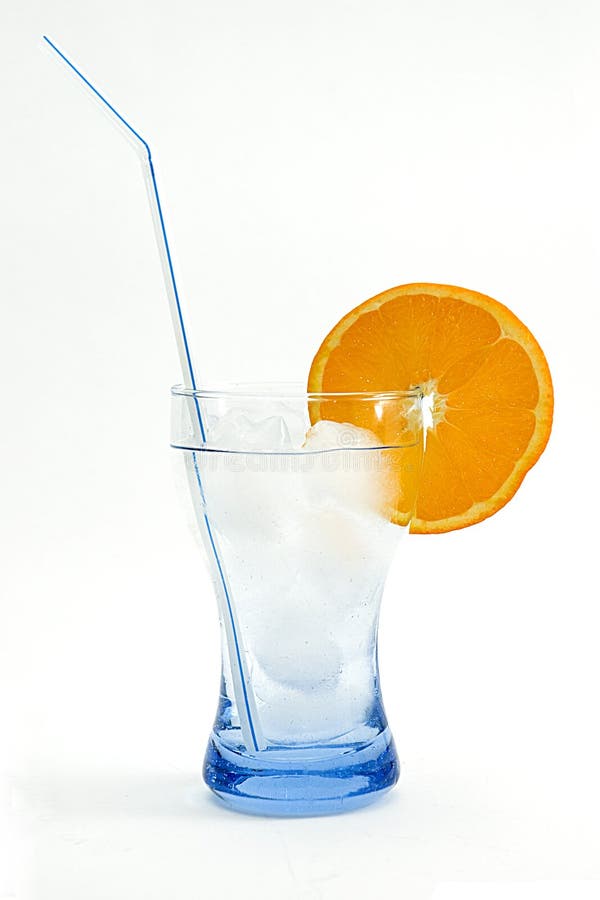 Cool drink in blue glass with ice cubes and orange white background