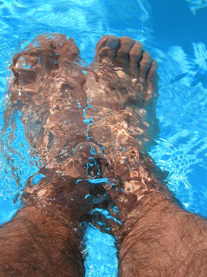 Cooling off feet in swimming pool. Cooling off feet in swimming pool