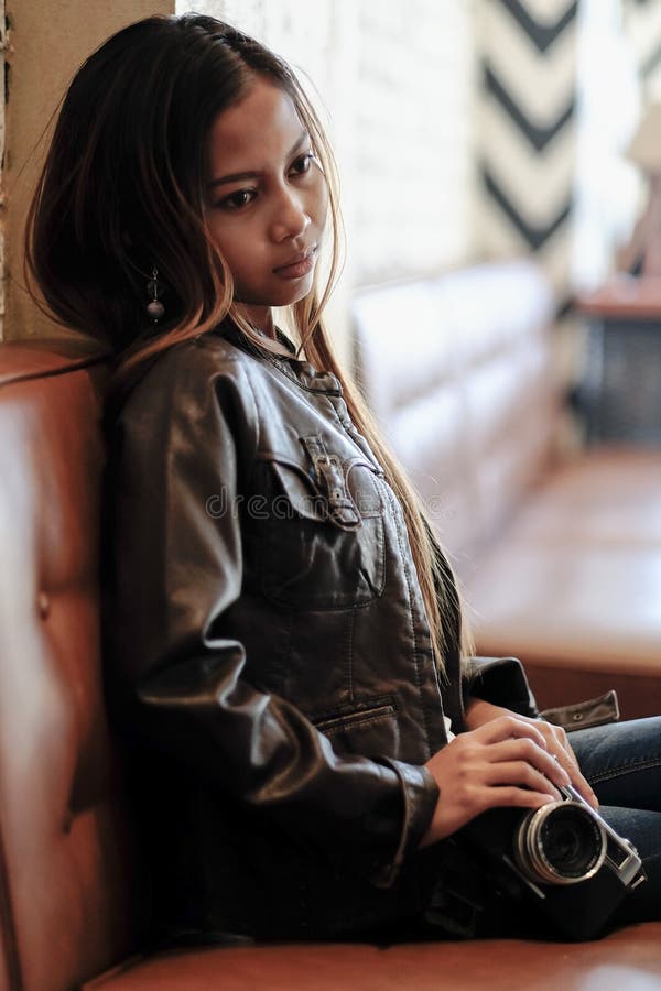 Cool Hipster Girl in a Leather Jacket Holding Camera Stock Photo