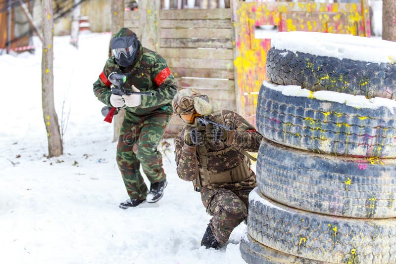 Cool Paintball in Winter. Two Shooters Behind Fortifications. Stock