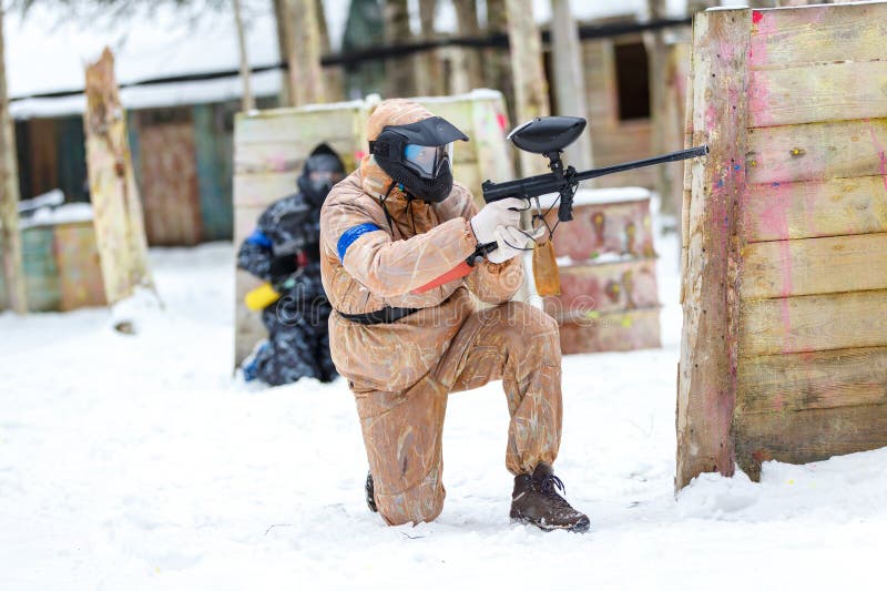 Cool Paintball in Winter. Two Shooters Behind Fortifications. Stock