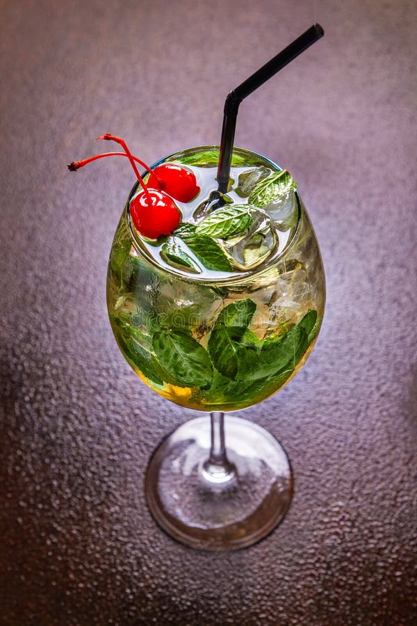 A cool summer cocktail with ice cubes, mint leaves and fresh juice decorated with two cherries. Fresh mint julep stock image A cool summer cocktail with ice cubes, mint leaves and fresh juice decorated with two cherries. Fresh mint julep stock image
