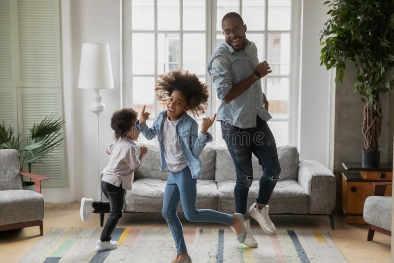 Cool Vater, der zu Hause zwei Kinder amüsiert stockbild
