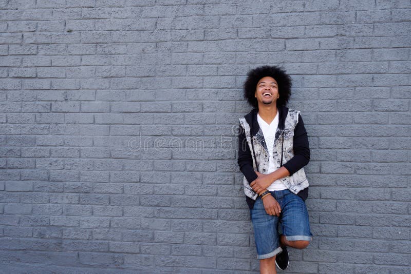 Cool young man with afro leaning against wall royalty free stock photos Cool young man with afro leaning against wall royalty free stock photos