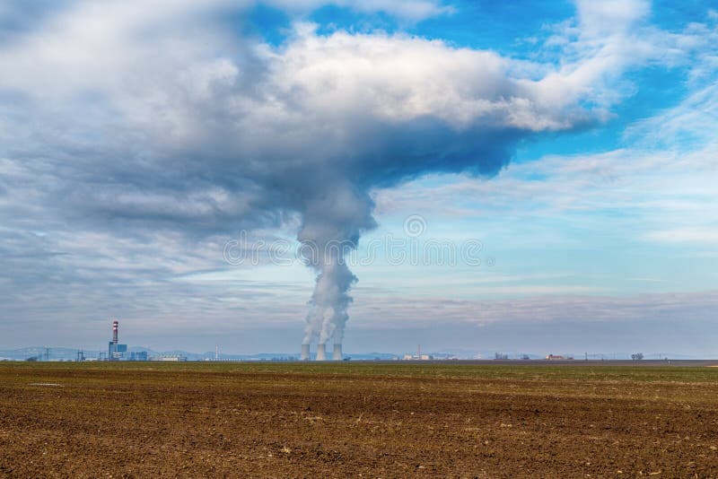 Chladicí věže jaderné elektrárny Jaslovské Bohunice EBO na Slovensku. Mraky hustého kouře z komínů na modré obloze