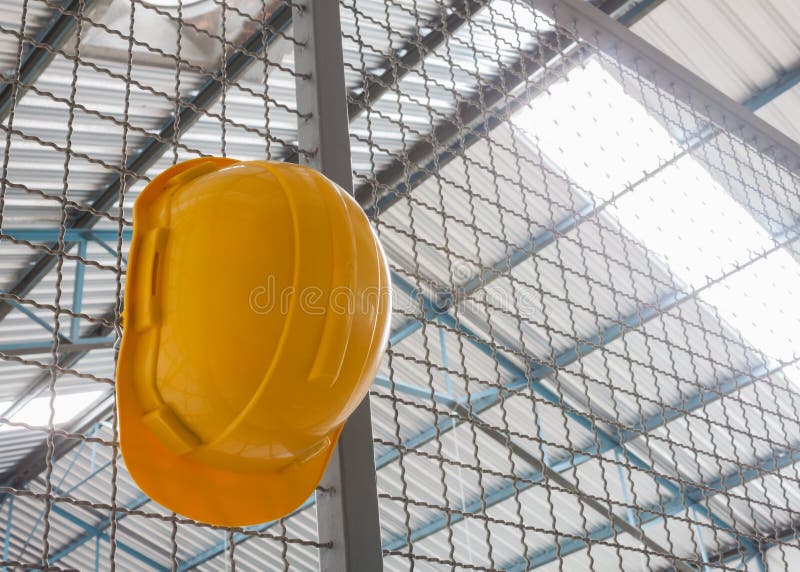 Coordenador de segurança amarelo Helmet com rede de arame de aço fotografia de stock