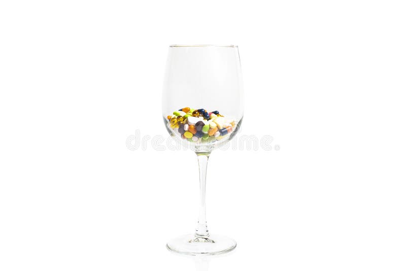 Copa de vino con muchas píldoras multicoloras, tabletas y cápsulas, aisladas en el fondo blanco con el espacio de la copia fotos de archivo Copa de vino con muchas píldoras multicoloras, tabletas y cápsulas, aisladas en el fondo blanco con el espacio de la copia fotos de archivo
