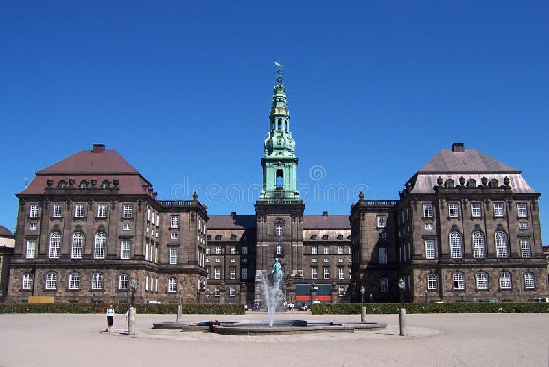 A famous Copenhagen (Kopenhavn, Kopenhagen) building, well known touristic destination. It is called Christianborg Slot. Clear blue sky. Some people walking and admiring the building. Capital of Denmark. A famous Copenhagen (Kopenhavn, Kopenhagen) building, well known touristic destination. It is called Christianborg Slot. Clear blue sky. Some people walking and admiring the building. Capital of Denmark.