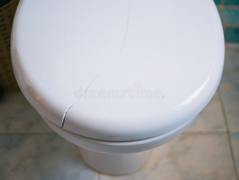 Coperchio della toilette rotto Crack sul coperchio della toilette Chiudi fotografia stock