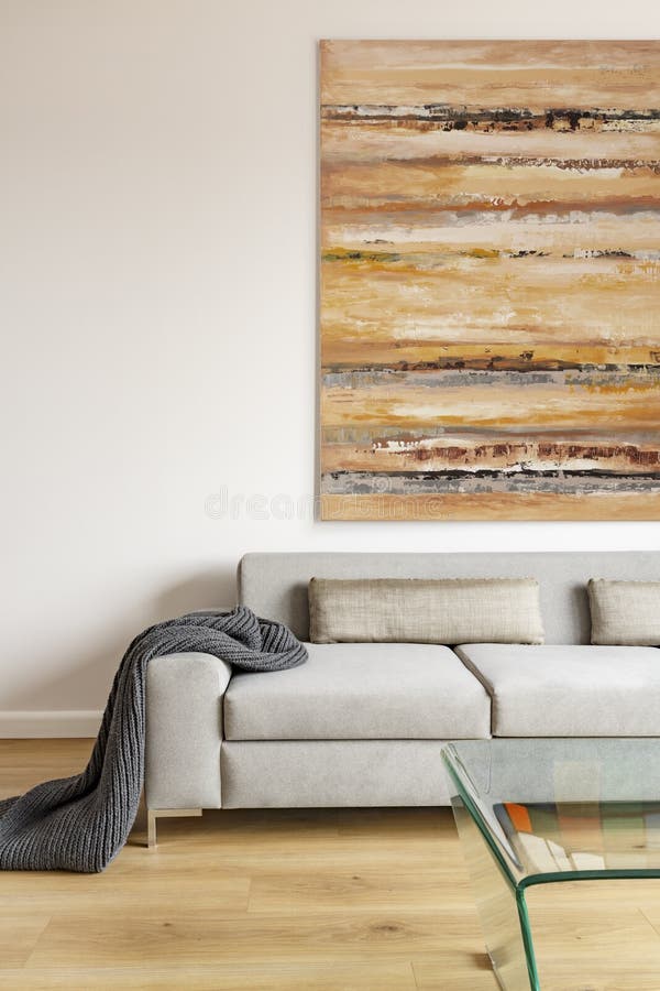 Coperta sul divano beige nell'ambito di pittura variopinta nella vita moderna immagine stock libera da diritti Coperta sul divano beige nell'ambito di pittura variopinta nella vita moderna immagine stock libera da diritti