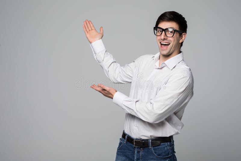 Copi lo spazio alla sua mano Uomo maturo felice in camicia che indica lo spazio della copia e che sorride mentre stando contro il immagini stock Copi lo spazio alla sua mano Uomo maturo felice in camicia che indica lo spazio della copia e che sorride mentre stando contro il immagini stock