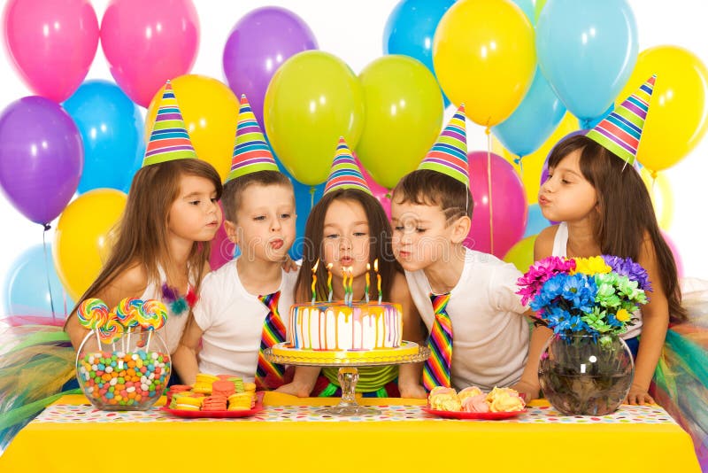 Copii sărbătoresc ziua de naștere și suflare stock photography