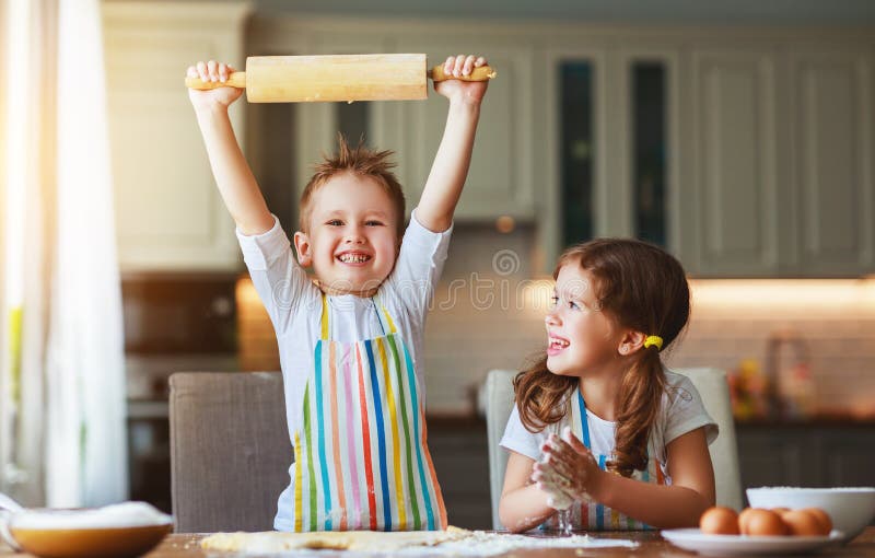 Copii veseli nostimi din familie fac prăjituri în bucătărie royalty free stock photo