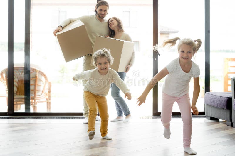 Copii veseli și amuzanți care fug în casa nouă în mișcare stock photos