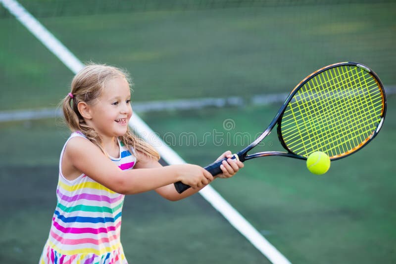 Copiii care joacă tenis pe teren în aer liber royalty free stock image