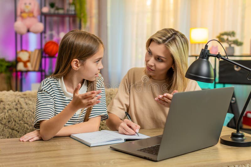 Copil fată copil cu mama studia la domiciliu pe canapea și de a face note de teme de acasă în notebook-ul școlii royalty free stock images