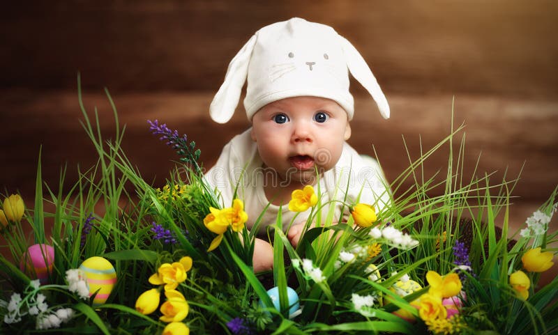 Copil fericit îmbrăcat ca iepurașul de Paști pe iarbă stock images