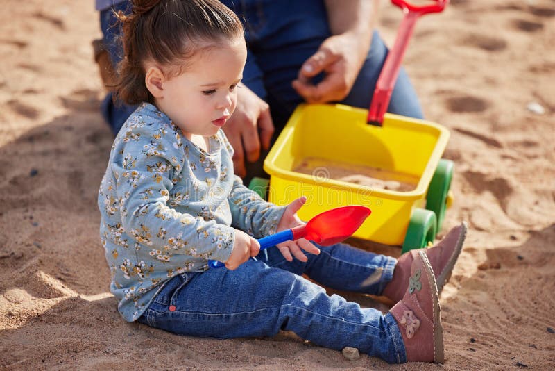 Copil-mamă și jucând cu jucării în nisip pentru unirea învățării curioase sau a dezvoltării cognitive. Persoană royalty free stock image