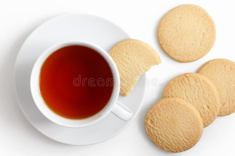 White cup of tea and saucer with shortbread biscuits from above. White cup of tea and saucer with shortbread biscuits from above