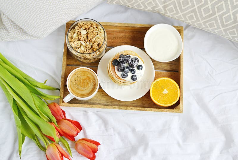 Copo com o café da manhã saudável alaranjado do cappuccino e do Granola caseiro das bagas do creme de leite das panquecas imagens de stock Copo com o café da manhã saudável alaranjado do cappuccino e do Granola caseiro das bagas do creme de leite das panquecas imagens de stock