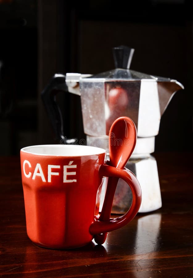 Copo de café e cafeteira vermelhos do vintage na tabela de madeira escura imagens de stock Copo de café e cafeteira vermelhos do vintage na tabela de madeira escura imagens de stock