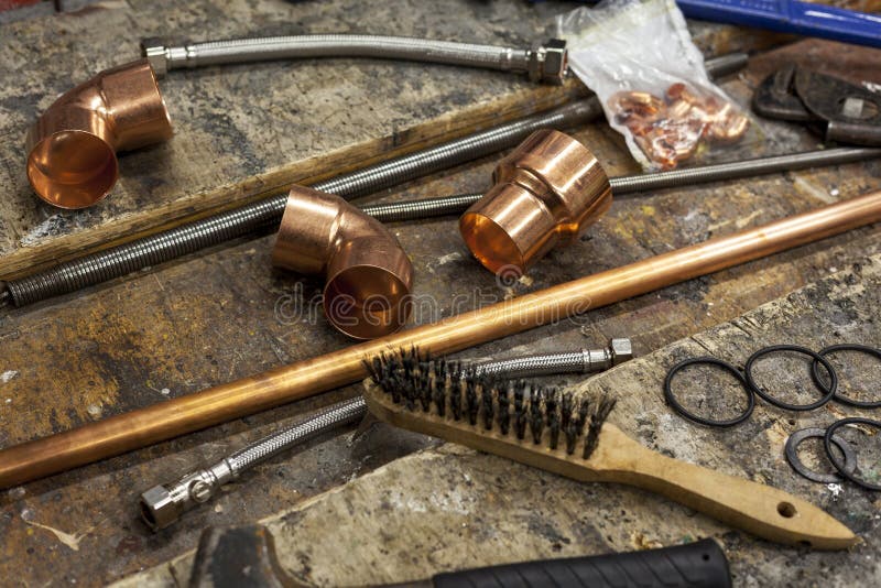 Copper plumbing fittings on a busy plumbers workbench royalty free stock photography Copper plumbing fittings on a busy plumbers workbench royalty free stock photography