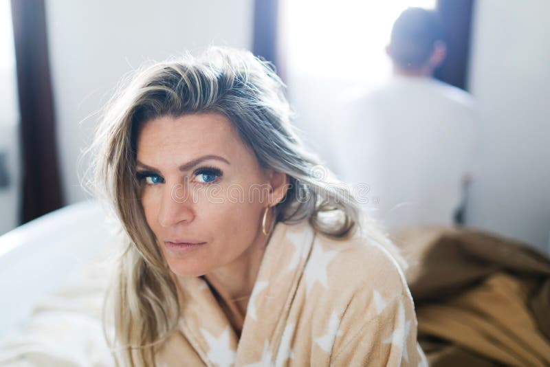 Coppia avere crisi a letto Donna che si siede sul bordo del letto - di nuovo alla parte posteriore fotografia stock libera da diritti Coppia avere crisi a letto Donna che si siede sul bordo del letto - di nuovo alla parte posteriore fotografia stock libera da diritti