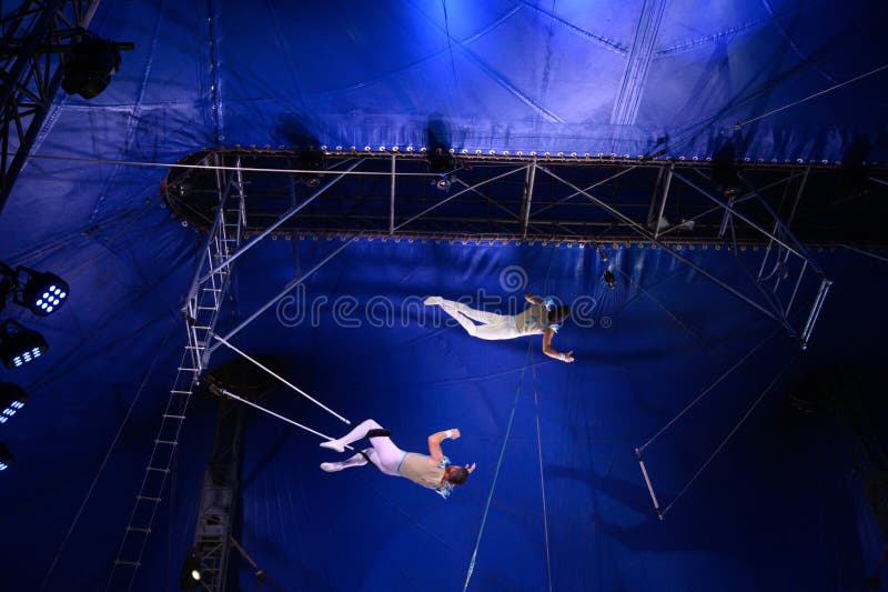 Coppia di acrobati che saltano sul trapezio immagine stock libera da diritti