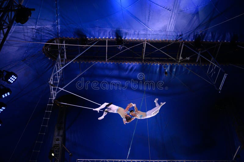 Coppia di acrobati che saltano sul trapezio fotografia stock