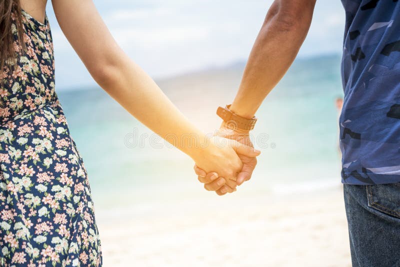 Coppia di innamorati si tengono insieme sulla spiaggia tropicale estiva. concentrarsi sulle mani con l'attività della felicità. vi immagine stock libera da diritti