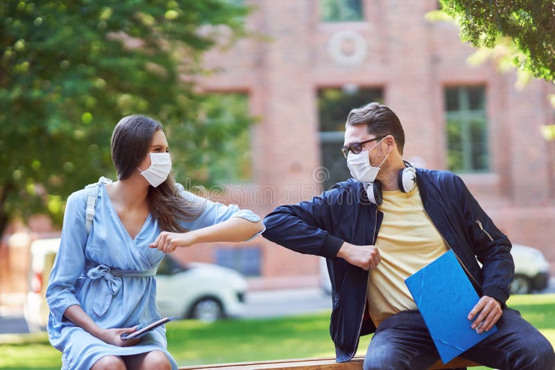 Coppia di studenti del campus indossano maschere a causa della pandemia di coronavirus immagini stock