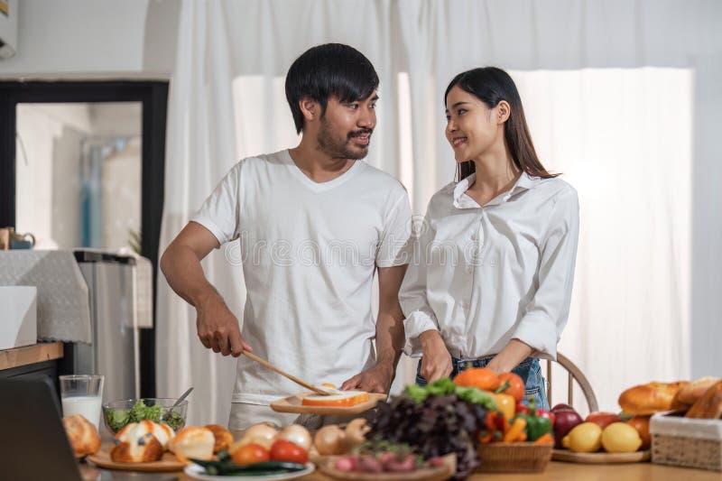 Coppia felice sorridente che cucina insieme e cucina sana coppia cucina cibo in cucina fotografie stock